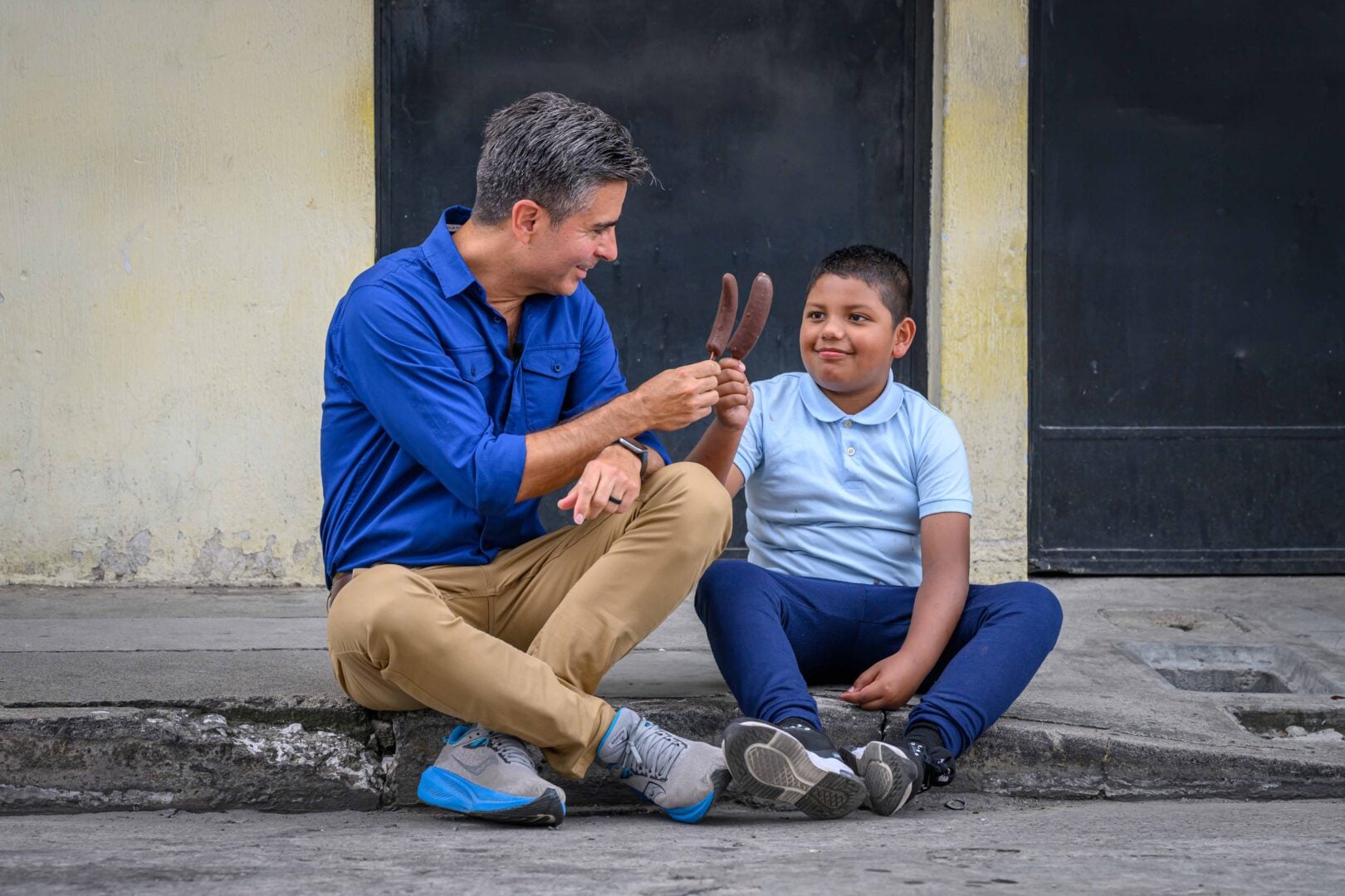 edgar eating a chocolate banana with a little kid