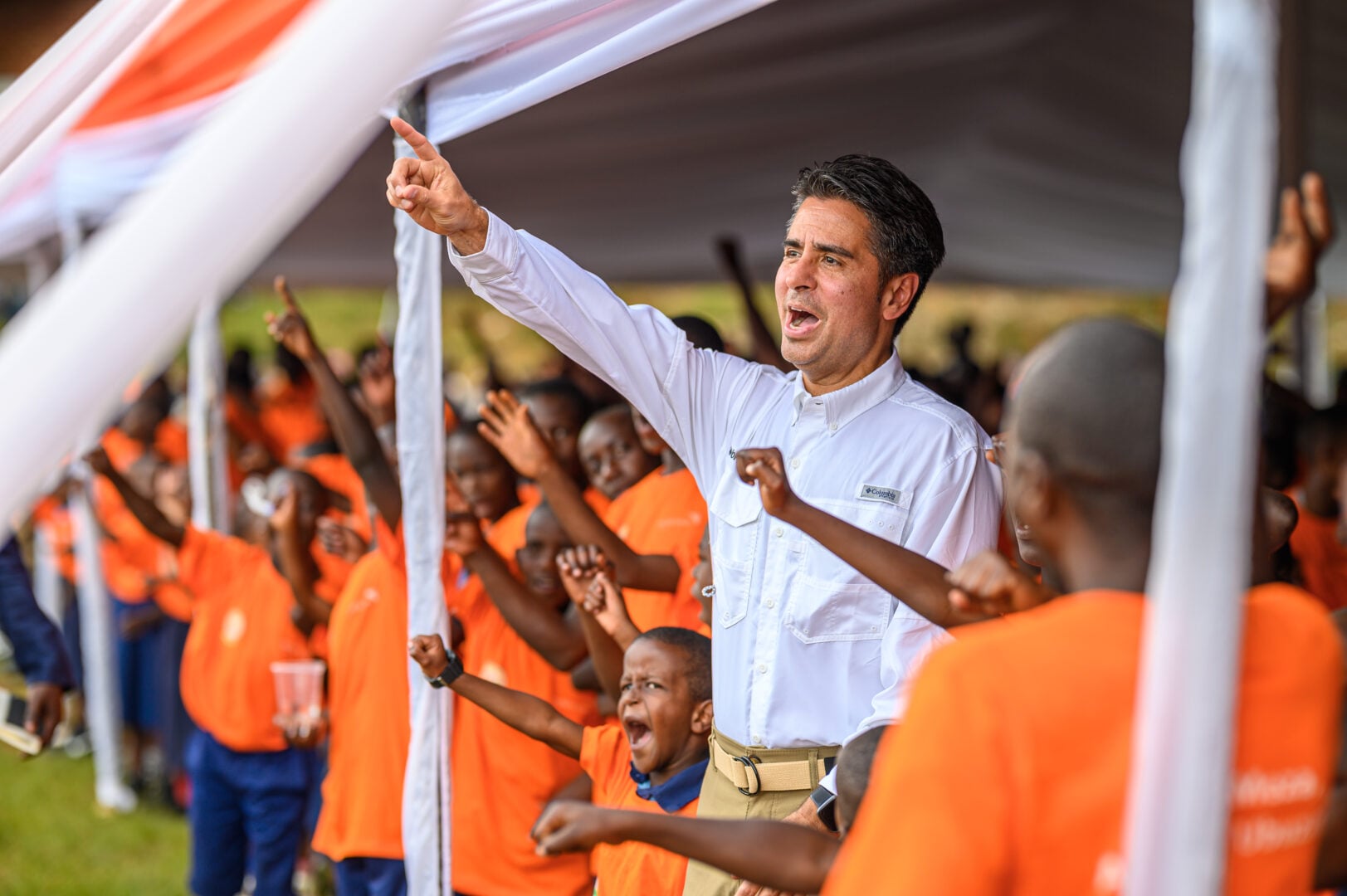 edgar singing and shouting with a group of people and kids