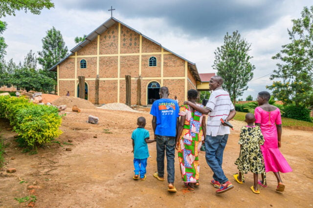 A family of six walks toward a church in Rwanda.